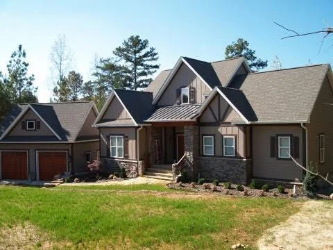 Brick and stone custom home with gabled roof, two-car garage, and front porch